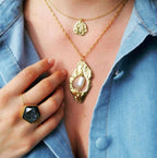 collier portée avec une chemise en jean bleu et un pendentif en forme de coeur